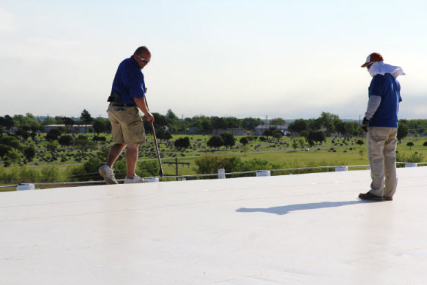 Two Coryell roofers inspecting a commercial roof