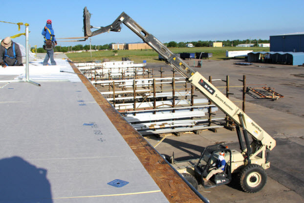 Coryell workers loading roofing materials onto a commercial roof