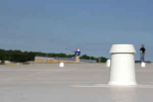 Commercial roofing system with workers in the background