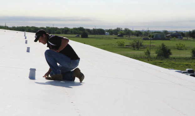 Coreyll Roofing team member inspecting a commercial roof.