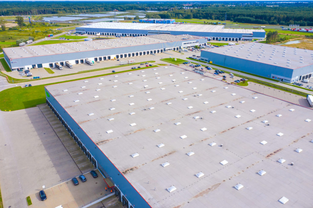 Aerial drone view of group of large modern industrial warehouse